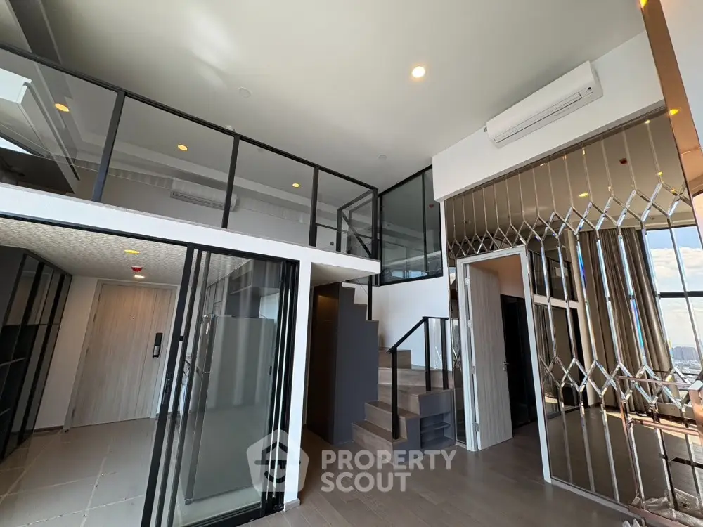 Modern duplex apartment with mezzanine and stylish staircase, featuring floor-to-ceiling windows and sleek design.