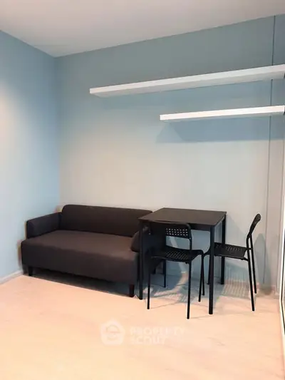 Modern minimalist living room with sleek black furniture and floating shelves.
