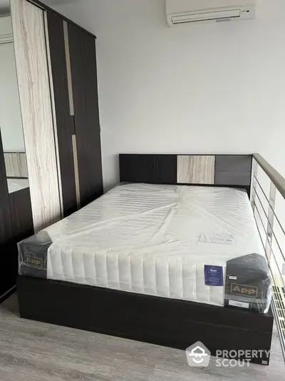 Modern bedroom with sleek design and air conditioning, featuring a new mattress and stylish wardrobe.