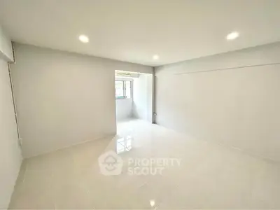 Spacious unfurnished room with bright lighting and tiled flooring, ideal for customization.