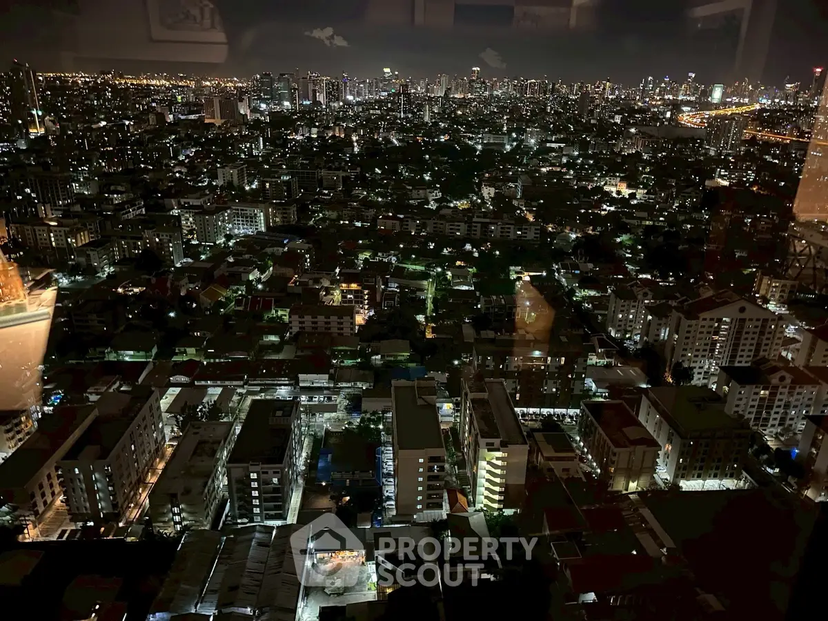 Stunning nighttime cityscape view from a high-rise apartment, showcasing vibrant urban lights and skyline.