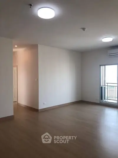 Spacious empty living room with wooden flooring and natural light