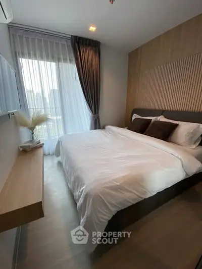 Cozy modern bedroom with large window and elegant decor