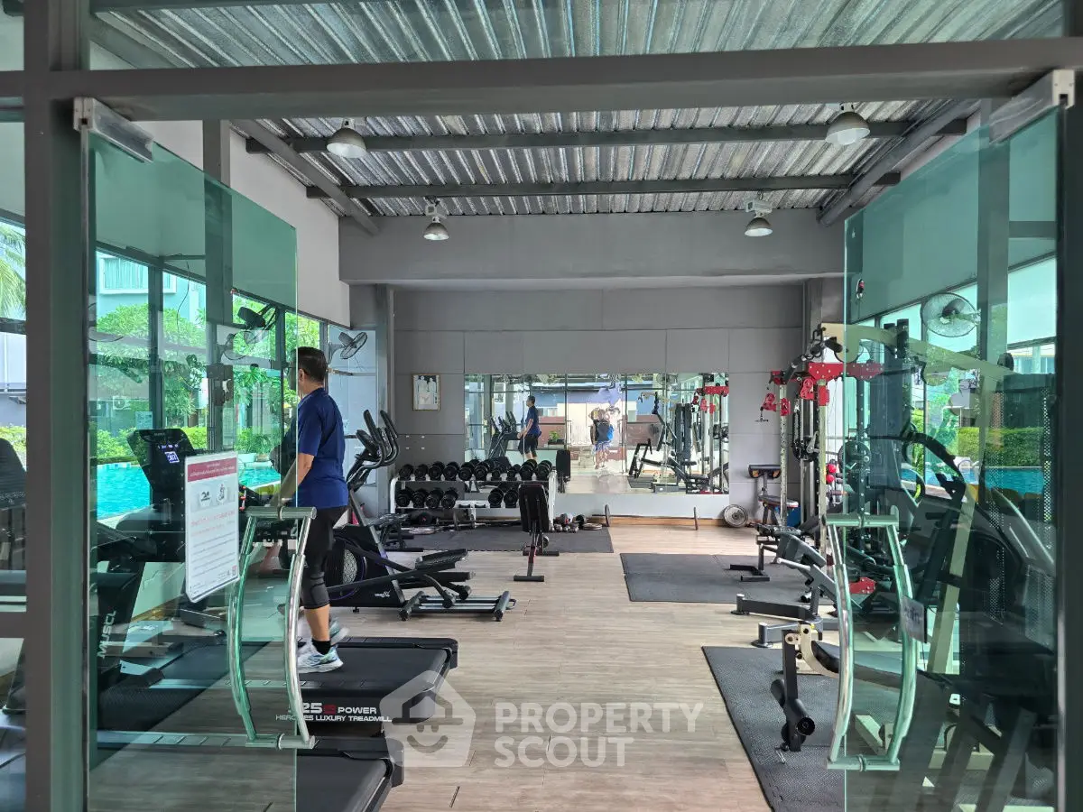 Modern gym with glass walls and fitness equipment in a residential complex