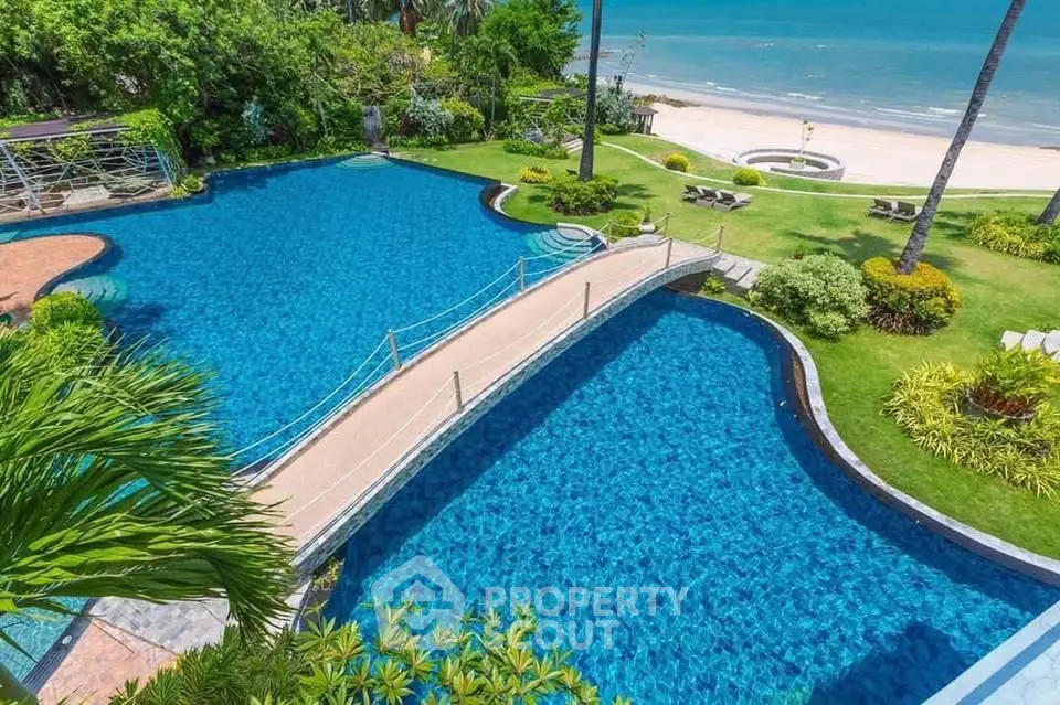 Luxurious beachfront pool with stunning ocean view and lush garden landscaping.
