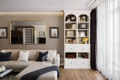 Elegant living room with stylish decor and natural light, featuring a cozy sofa and built-in shelving.