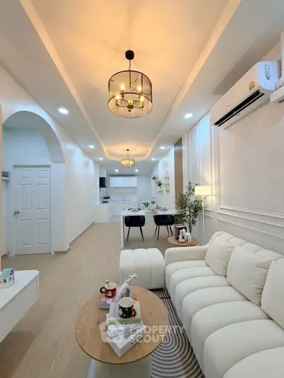 Modern living room with elegant lighting and cozy seating in open layout apartment.