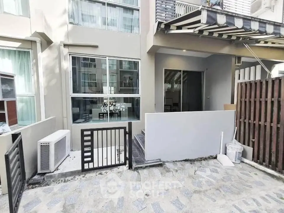 Modern townhouse exterior with gated entrance and large windows
