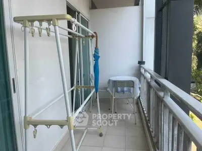 Spacious balcony with seating area and drying rack, perfect for relaxation and utility.
