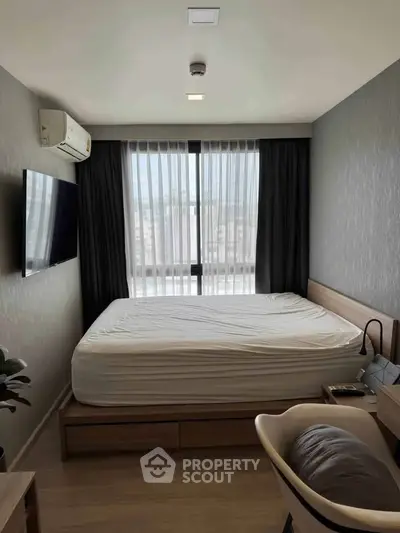 Modern bedroom with large window, stylish decor, and natural light.