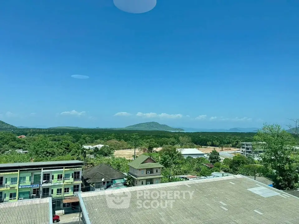 Stunning panoramic view from a high vantage point showcasing lush greenery and distant hills under a clear blue sky.