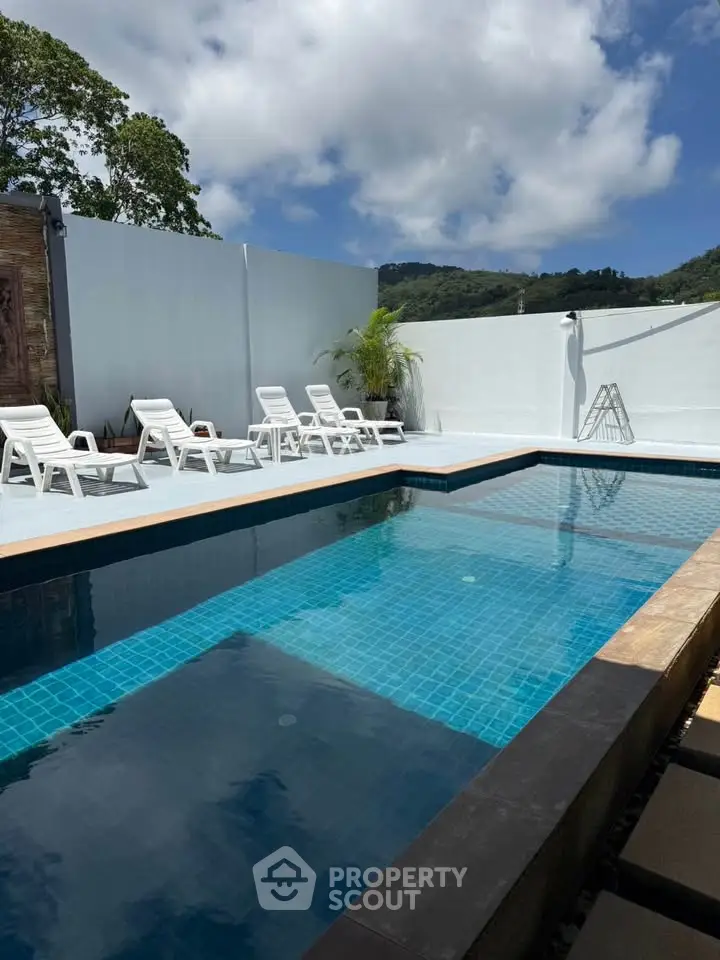 Luxurious outdoor pool area with sun loungers and scenic mountain views, perfect for relaxation and leisure.