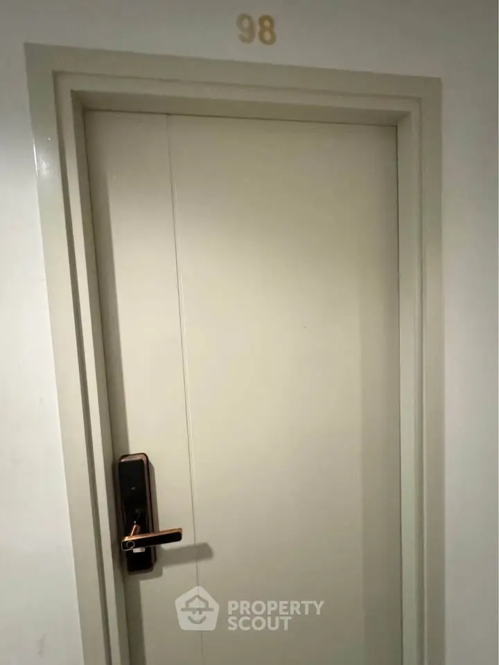 Modern apartment entrance with sleek door and electronic lock