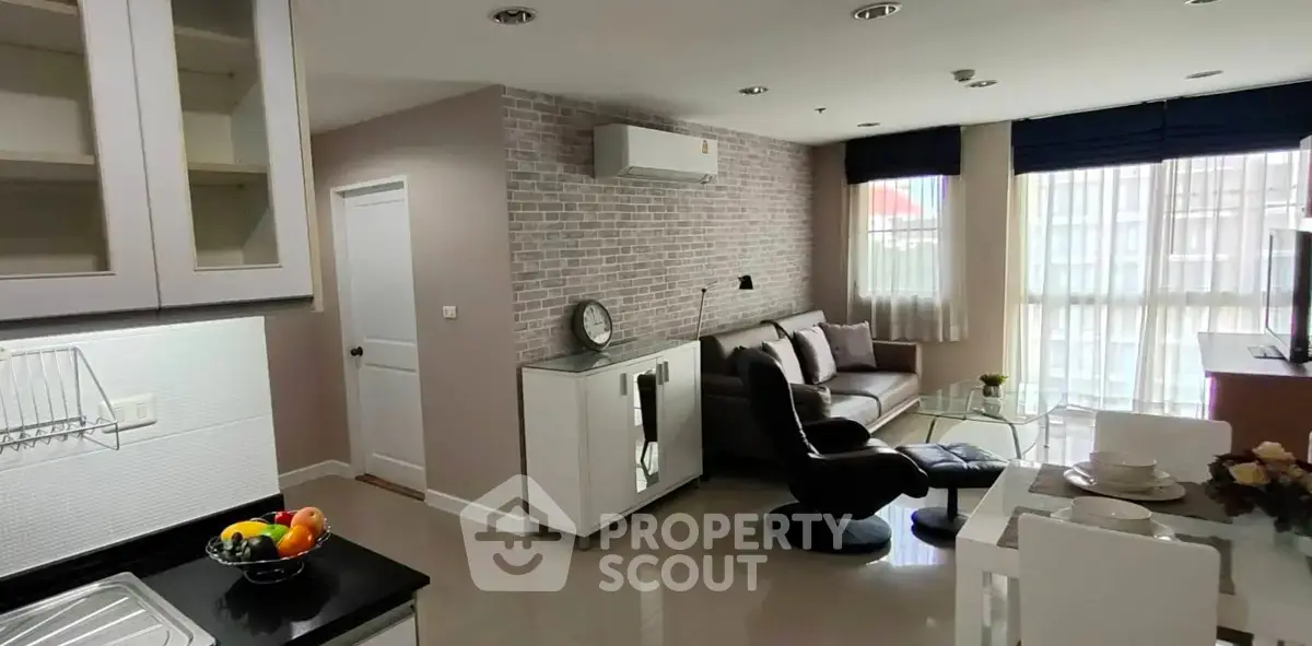 Modern living room with open kitchen, stylish decor, and natural light in a contemporary apartment.