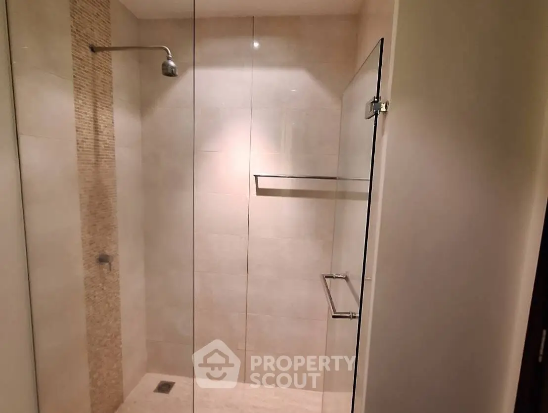 Modern bathroom with glass shower enclosure and elegant tile design.