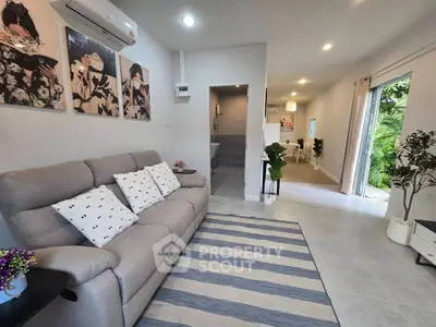 Modern living room with stylish decor and garden view, featuring cozy sofa and elegant lighting.