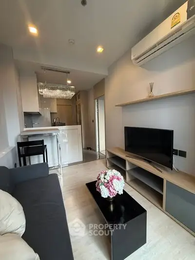 Modern living room with open kitchen, sleek furniture, and elegant decor in a stylish apartment.