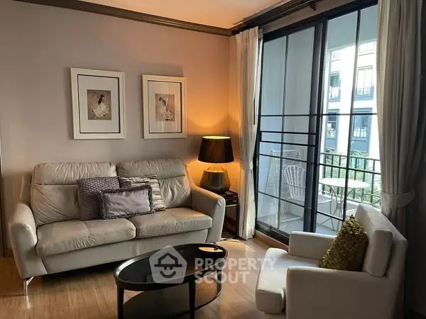 Cozy living room with modern furniture and balcony view in urban apartment.