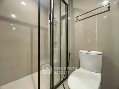Modern bathroom with glass shower enclosure and sleek toilet design.