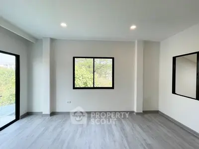 Spacious modern room with large windows and sleek flooring, perfect for customization.