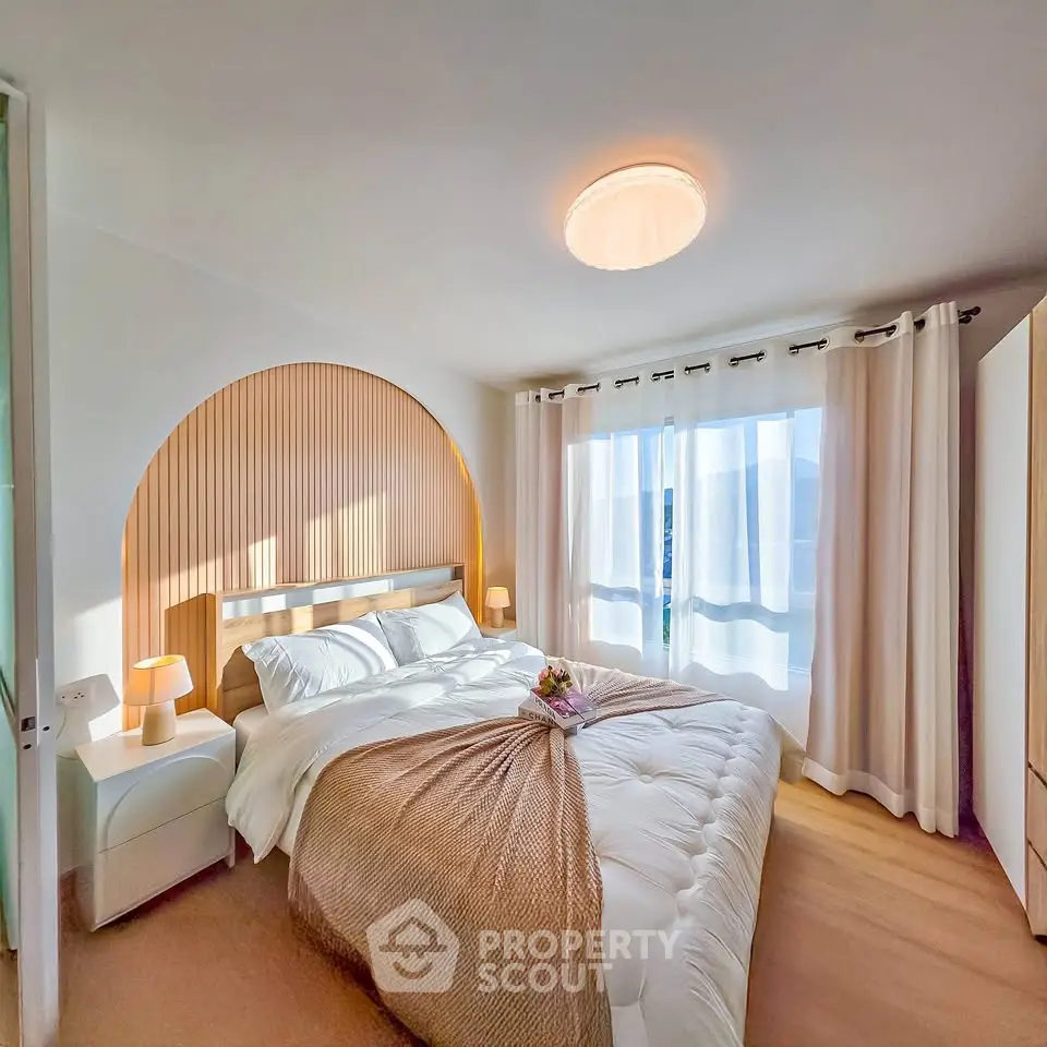 Bright and cozy bedroom with modern decor and large window for natural light.