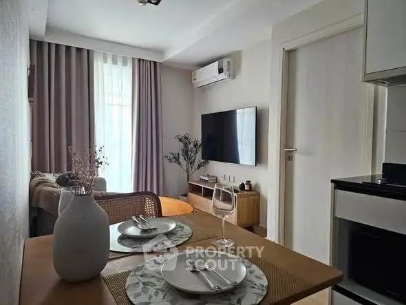 Modern living room with dining area, featuring a wall-mounted TV and air conditioning.