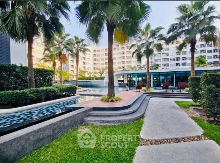 Luxurious poolside view with palm trees and modern architecture in a serene residential complex.