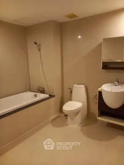 Spacious modern bathroom with bathtub and sleek fixtures in a contemporary apartment.