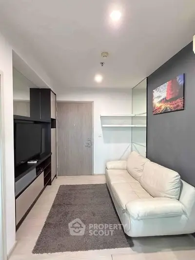 Modern living room with sleek design, featuring a white sofa, wall-mounted TV, and stylish decor.