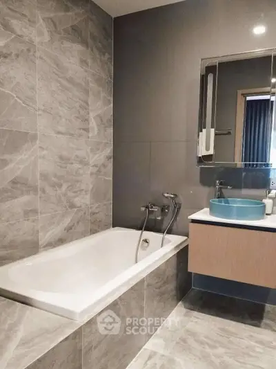 Modern bathroom with sleek design featuring a bathtub and stylish sink.