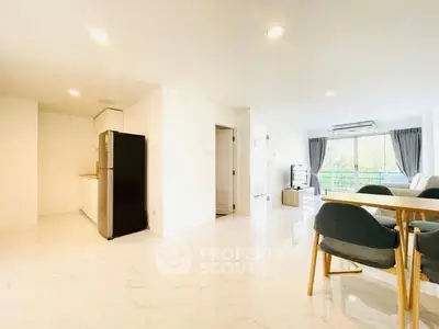 Spacious open-plan living and dining area with modern kitchen and natural light.