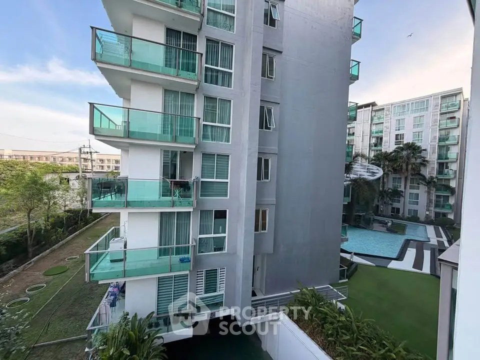 Modern apartment building with glass balconies and pool view