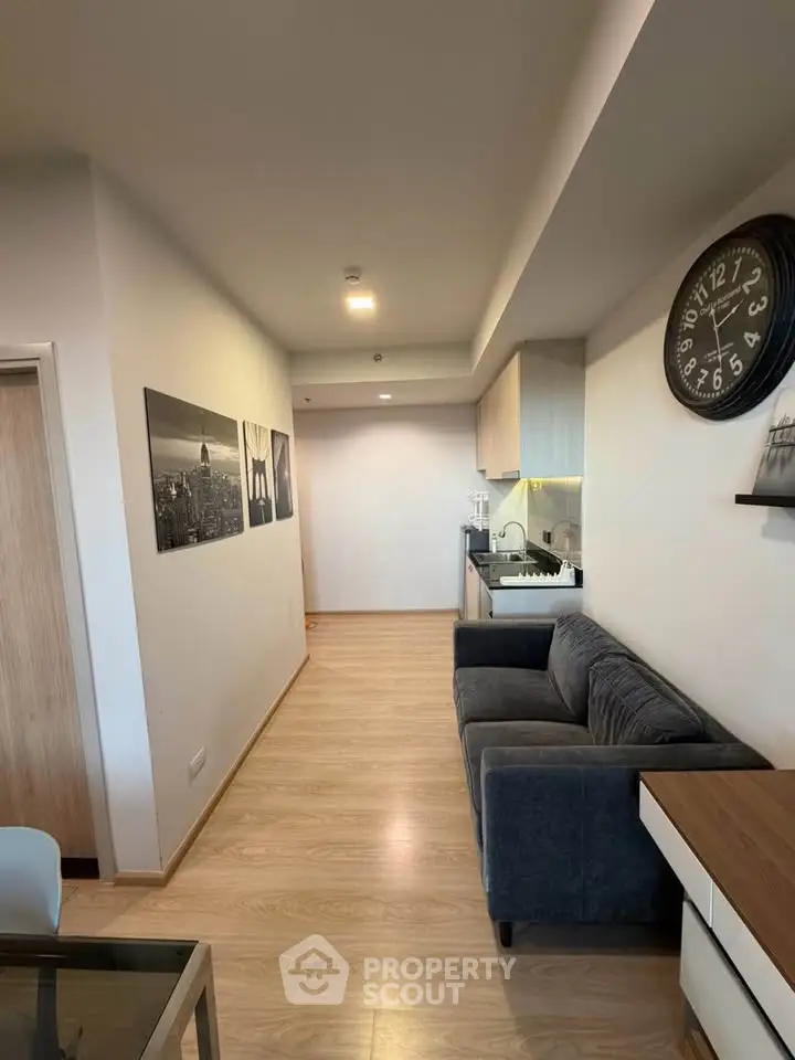 Modern living room with sleek kitchen, stylish decor, and cozy seating in a contemporary apartment.