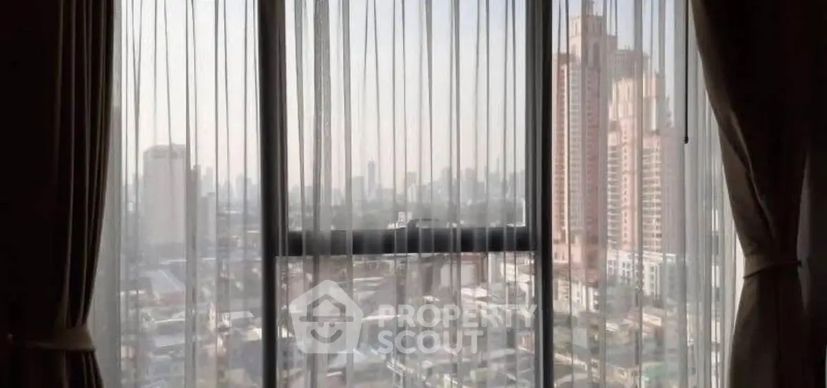 High-rise city view through elegant sheer curtains in modern apartment.