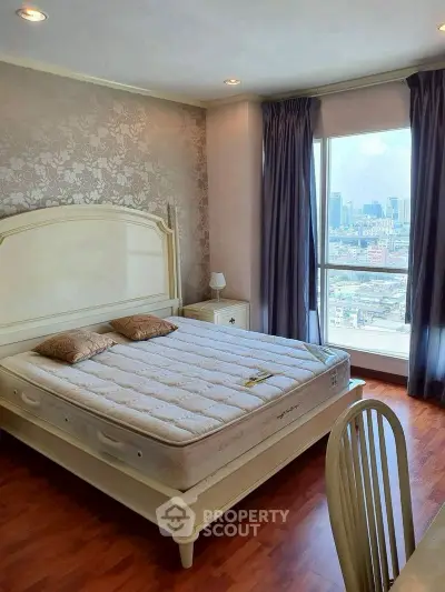 Elegant bedroom with city view, featuring a classic bed and stylish decor.
