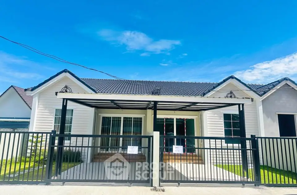 Charming single-story house with modern design and gated front yard under clear blue sky.