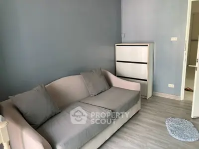 Cozy living room with modern gray sofa and sleek storage unit, perfect for relaxation.