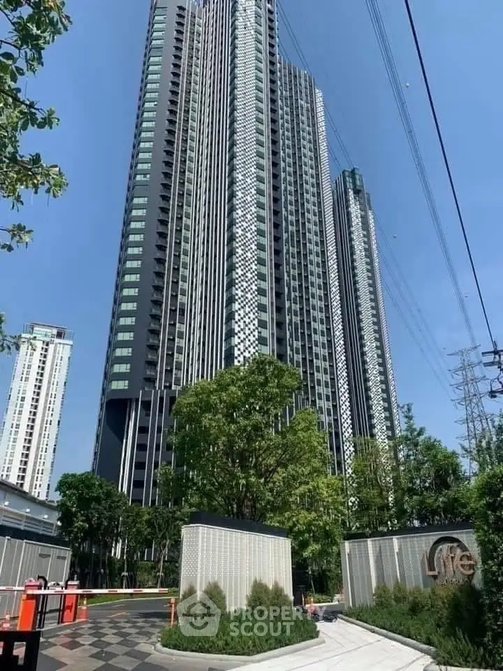 Stunning modern high-rise building with lush greenery and clear blue sky.