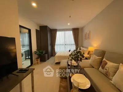 Modern living room with cozy seating and stylish decor in a well-lit apartment.
