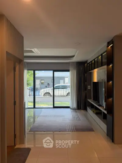Modern living room with large glass doors and sleek entertainment unit