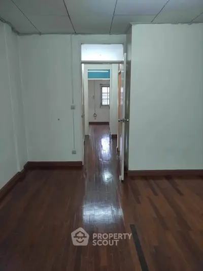 Spacious empty room with polished wooden floors and natural light