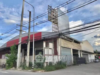 Spacious industrial warehouse with ample outdoor space and secure fencing, ideal for business operations.