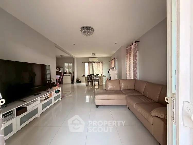 Spacious living room with modern decor and large TV, perfect for family gatherings.