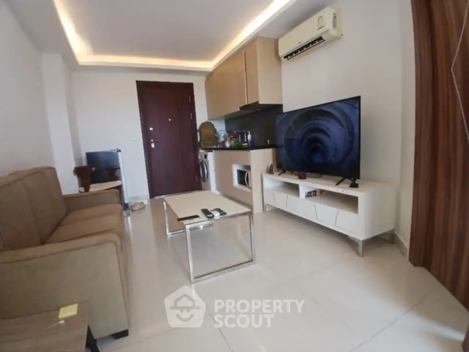 Modern living room with sleek furniture, flat-screen TV, and stylish lighting in a contemporary apartment.