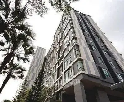 Modern high-rise building with sleek design and lush greenery