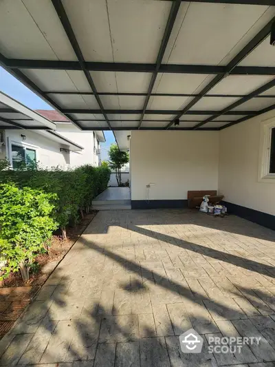 Spacious covered patio with lush greenery in modern residential property