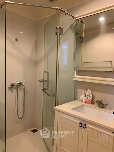 Modern bathroom with glass shower and elegant vanity in a stylish home.