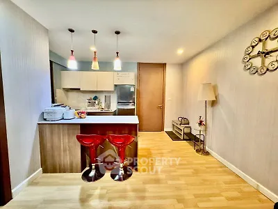 Modern kitchen with open layout and stylish bar stools in a cozy apartment setting.