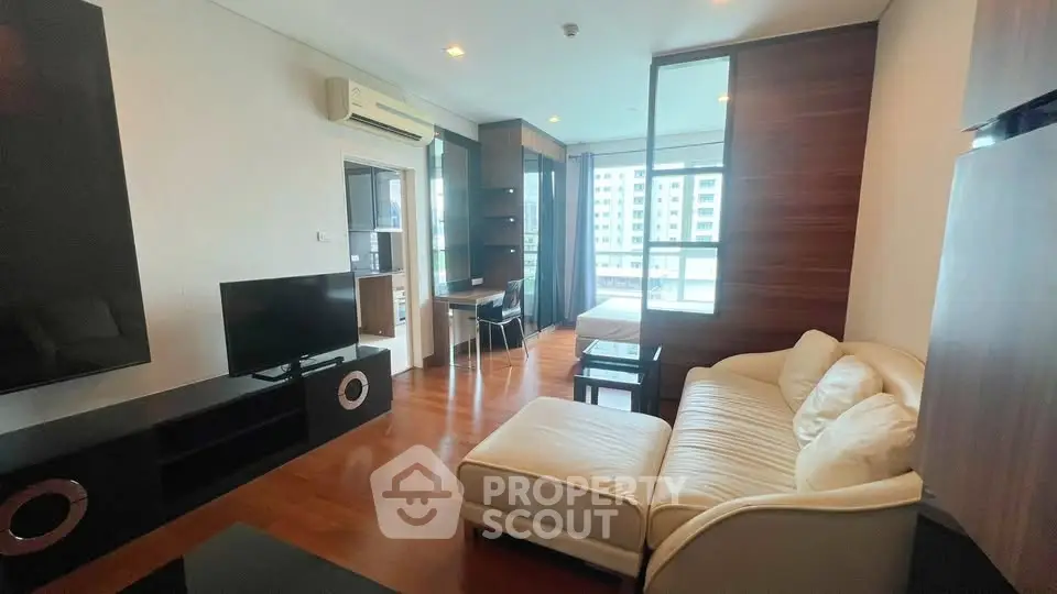 Modern living room with sleek furniture and large windows in a high-rise apartment