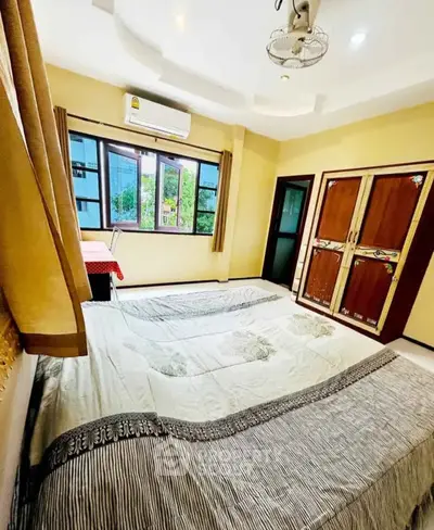 Spacious bedroom with large window and elegant decor in modern apartment